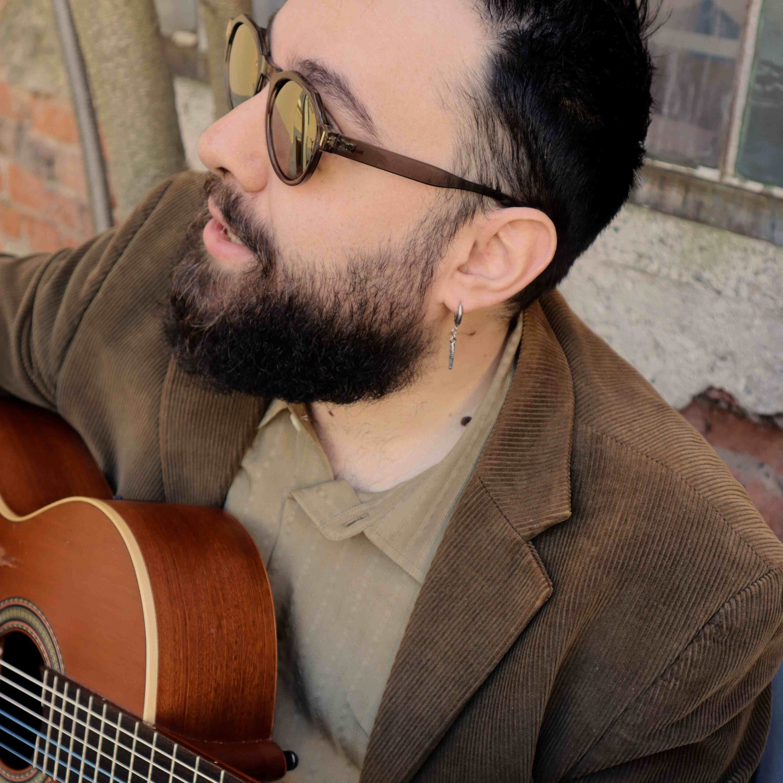 Alexis Metallinos playing an acoustic guitar.